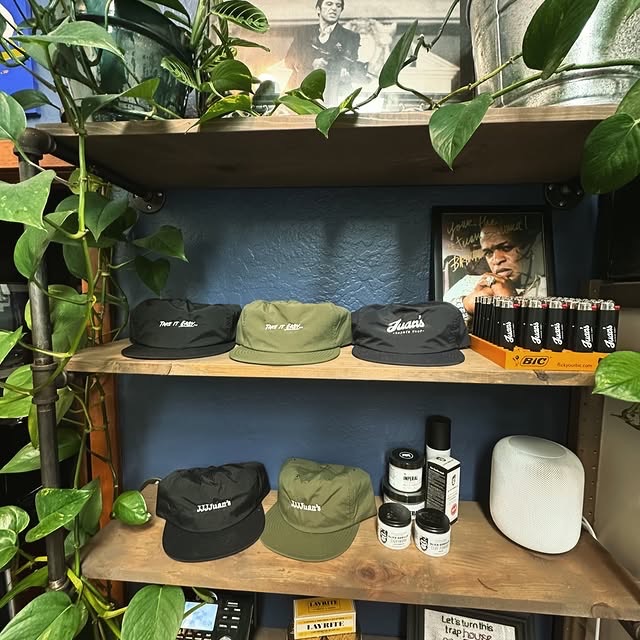 Juan’s Barbershop caps and grooming products on the shop’s wooden shelves