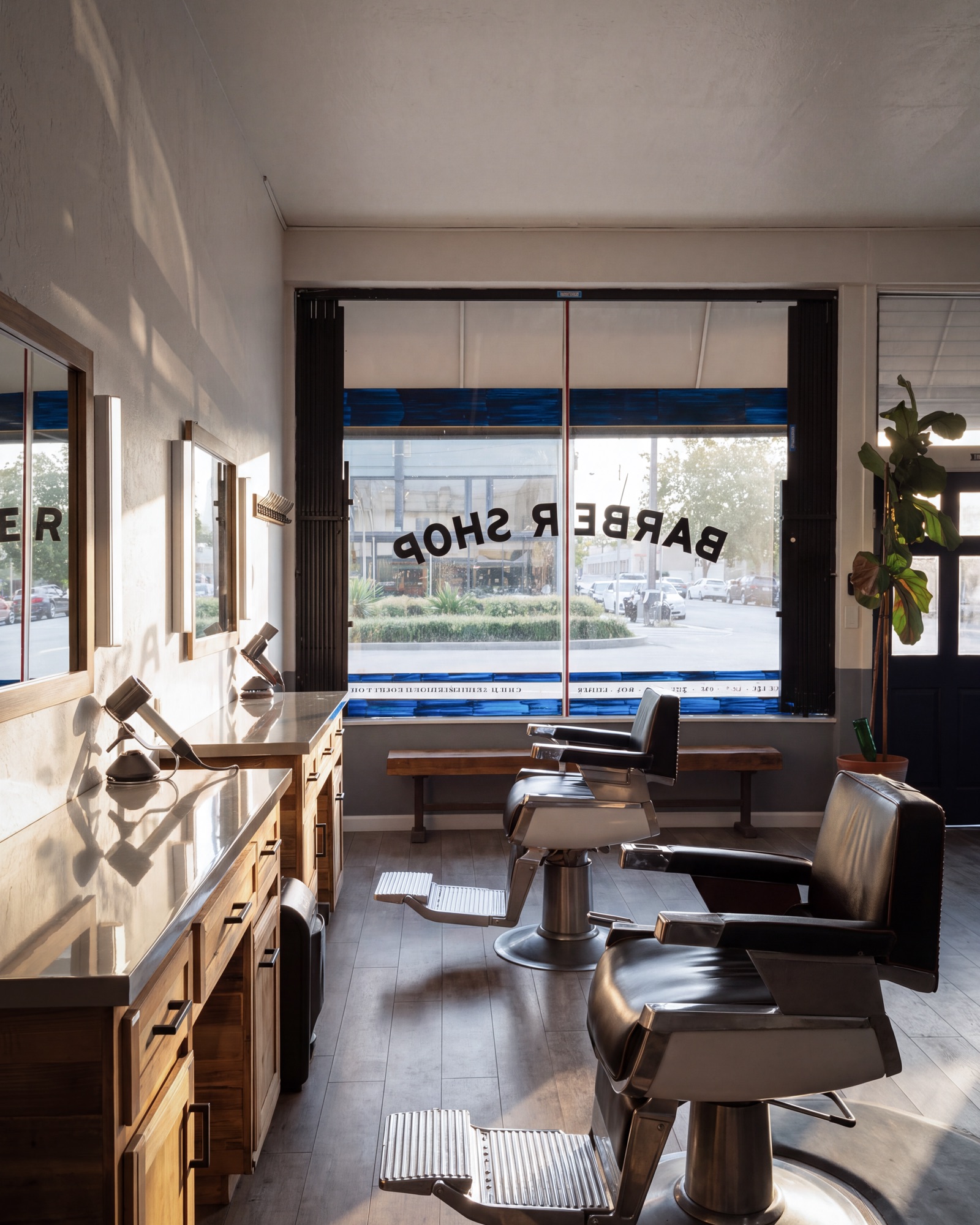 Barber chairs and wooden stations at Juan’s Barbershop, afternoon light coming through the storefront window