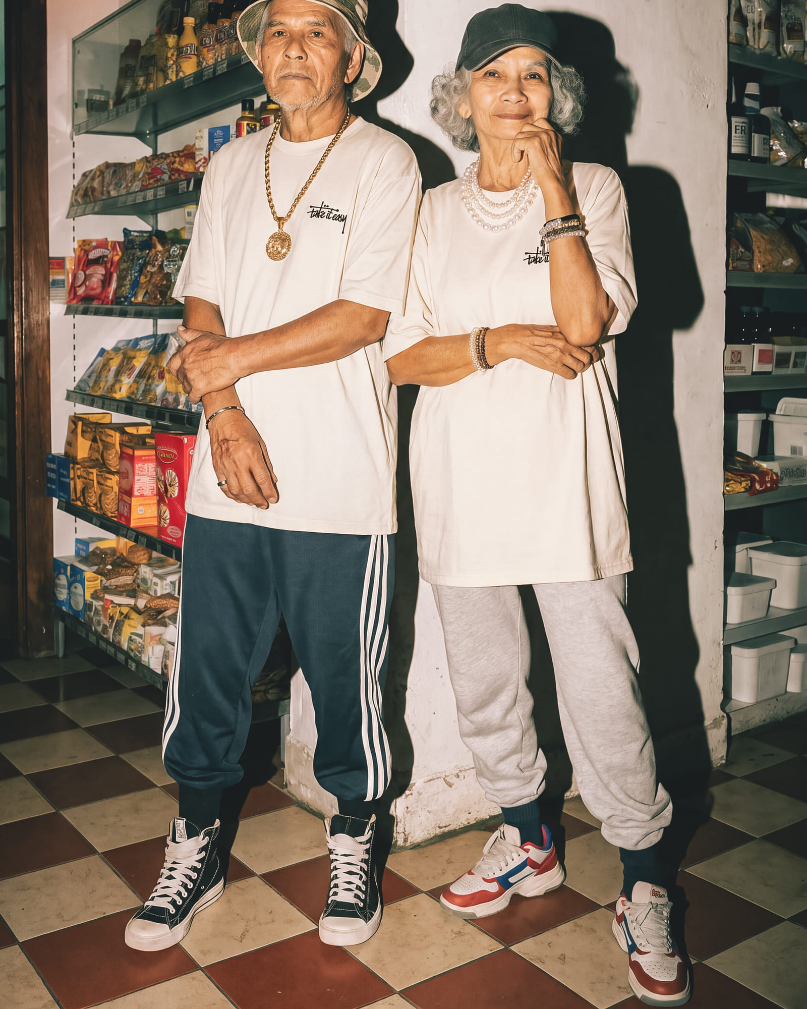 Two people wearing the cream Take It Easy tee, standing together in a corner store